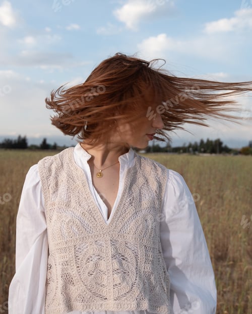 Preview: Young woman wearing white dress haking her hair