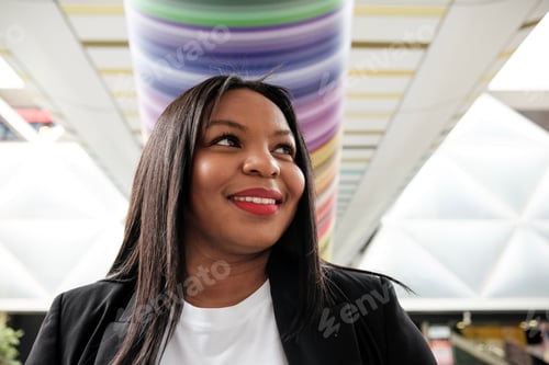 Preview: Smiling businesswoman walking in modern office building