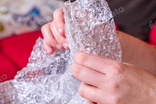 Preview: Stress concept. Woman's hands popping bubbles from a bubble paper.