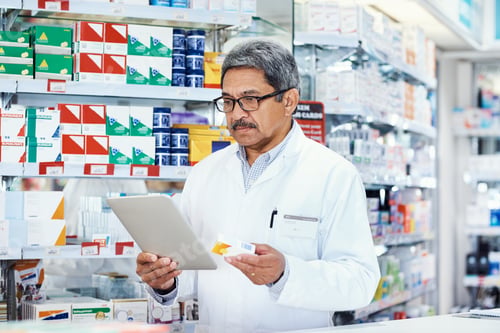 Preview: Shot of a mature pharmacist using a digital tablet in a chemist