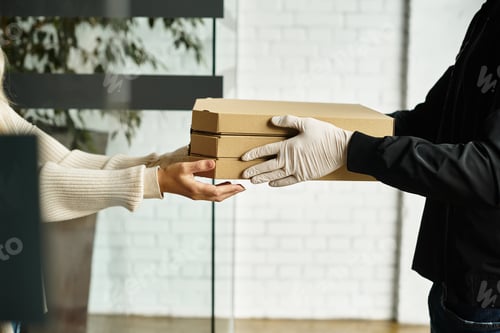 Preview: A delivery man gives a package to a woman in a modern office