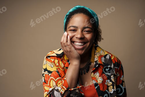 Preview: Young black woman in headband smiling and looking at camera