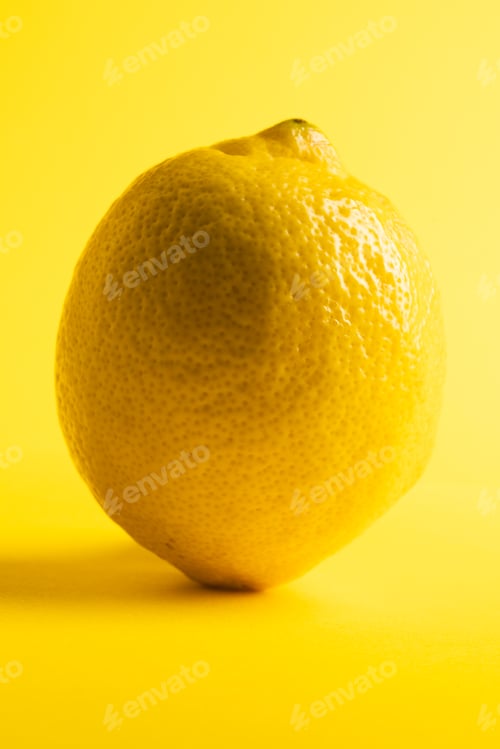 Preview: Close up of lemon and copy space on yellow background