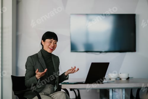 Preview: Asian businesswoman leading a video conference in modern office
