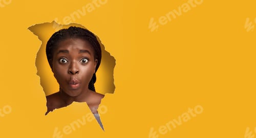 Preview: Surprised shocked black woman looking through paper hole