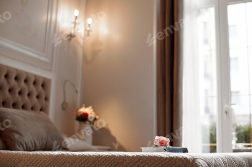 Preview: A pink and white rose is lying on a closed book on the bed in the bedroom