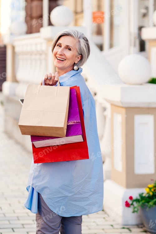 Preview: Beautiful senior woman shopping at clothing store