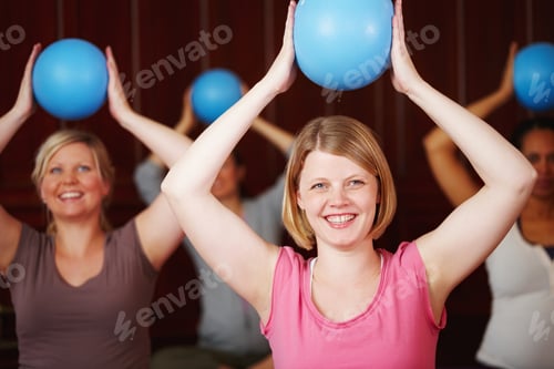 Women Doing Pilates with Balls in Fitness Class