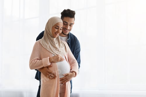 Preview: Loving arab man hugging his pregnant muslim wife's belly at home