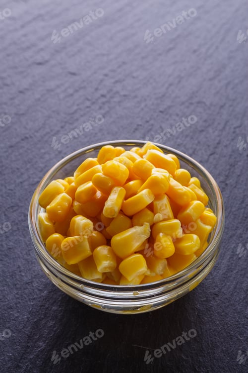 Preview: canned corn in a glass bowl on a dark stone background