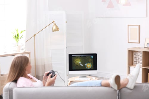 Preview: Emotional young woman playing video games at home