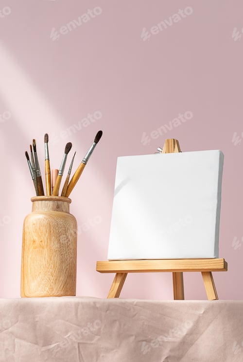 Preview: Blank white canvas and vase with paintbrushes for art. Artistic layout.