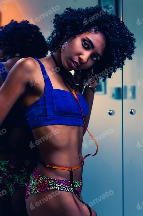 Preview: Latin Dominican woman posing for portrait, with afro hair and fitness body in front of mirror
