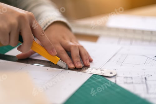 Preview: An architect working and cutting papers in office