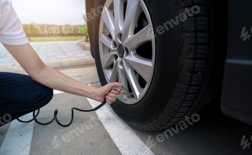 Preview: Woman inflates the tire. Woman checking tire pressure and pumping air into the tire of car wheel.