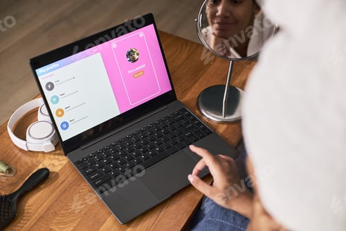 Preview: Young Adult Black Woman Using Laptop for Online Dating and Smiling at Reflection