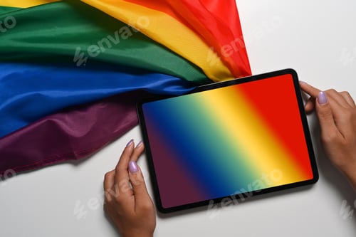 Preview: Above view female holding digital tablet with rainbow flag on white background.