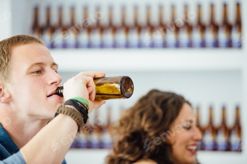 Preview: Man drinking beer with unfocused woman near