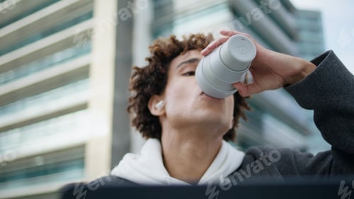 Preview: Earbuds hipster sipping coffee at urban place closeup. Student learning laptop