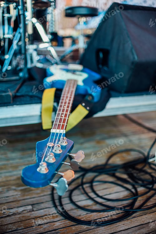 Preview: professional guitar lies on stage among wires and musical instruments. Selective focus on fretboard