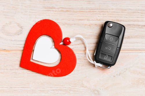 Preview: Top view of a present for Valentine's Day on wooden background. Close up of car key