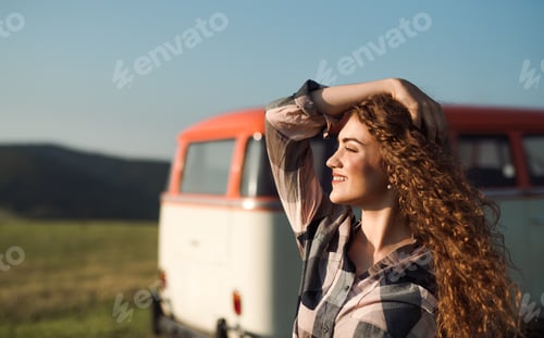 Preview: A young girl on a roadtrip through countryside, standing by a minivan.