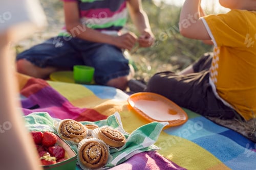 Preview: Children (4-5, 10-11) having picnic on beach
