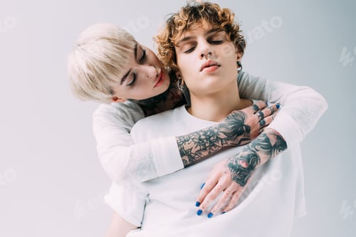 Preview: attractive girl hugging boyfriend with curly hair isolated on grey
