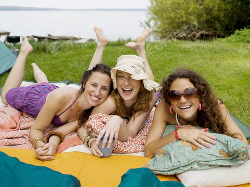 Preview: Three women laying on blankets smiling