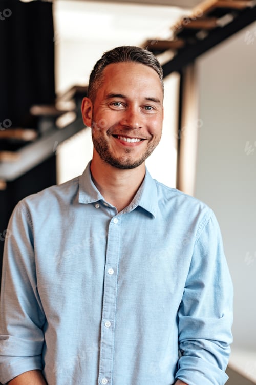 Preview: Confident young businessman standing near wooden ladder portrait