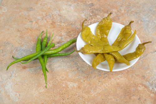 Preview: Pickled and fresh green peppers on white plate