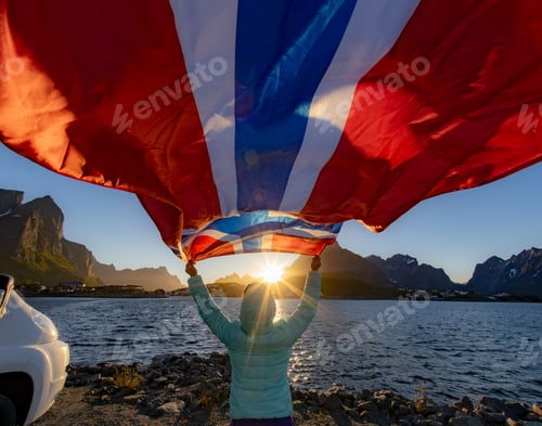 Preview: Woman with a waving flag of Norway on the background of nature