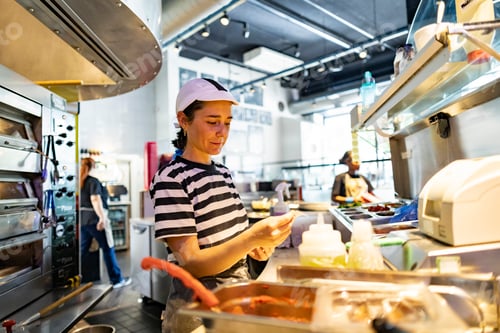 Preview: Pizza chef preparing ingredients in a busy london restaurant kitchen