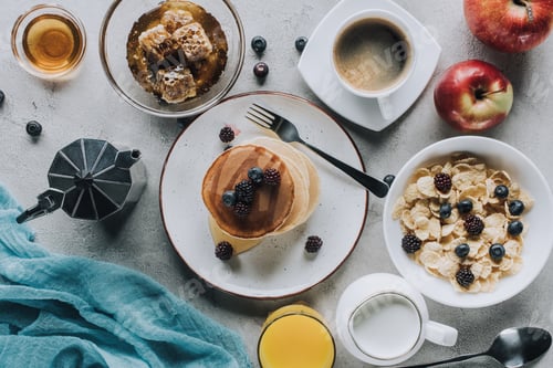Preview: top view of tasty healthy breakfast with pancakes, muesli and fruits on grey