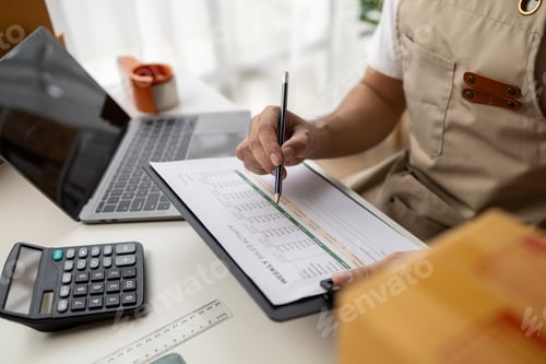 Preview: Man working, online shop owner checking orders from websites on the internet to confirm orders with
