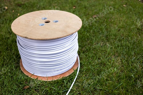 Preview: Top view of roll of white industrial electrical cable on large wooden reel