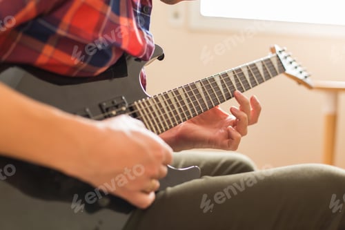 Preview: Millennial man playing, practicing electric guitar at home