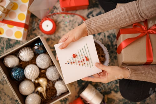 Preview: Lovely young woman hands holding a Christmas greeting card