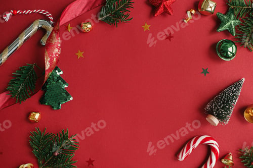 Preview: Modern christmas flat lay. Stylish christmas baubles, fir branches, tree on red background