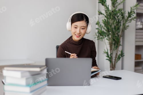 Preview: Asian student woman remote working with laptop and headphones