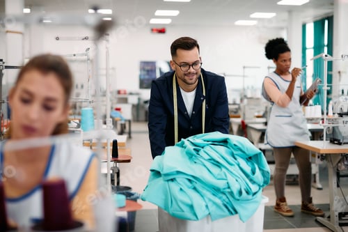Preview: Young man working as tailor in textile factory.