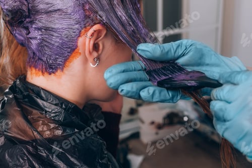Preview: Professional hairdresser dyeing hair of her client in salon. Selective focus