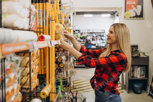 Preview: happy female customer shopping in hardware store.