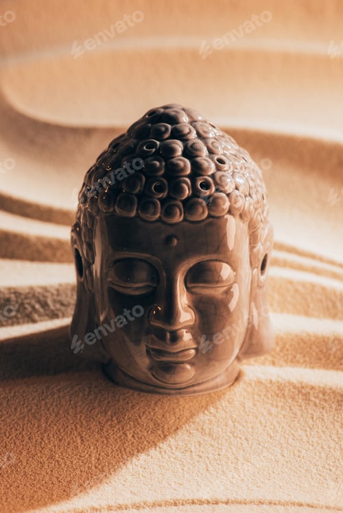 Preview: close up view of buddha sculpture on sandy beach
