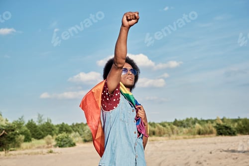 Preview: African man with rainbow flag outdoors
