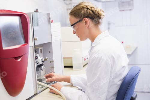 Preview: Analytical instrument processing samples at bright lab bench, with red housing and clear vials
