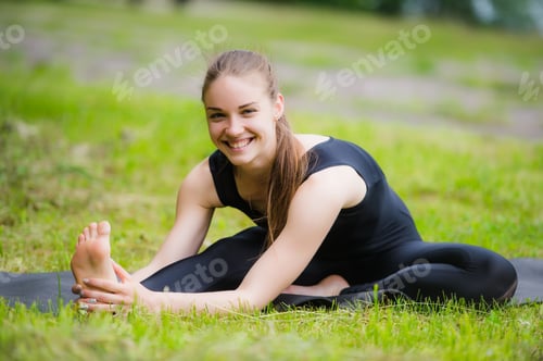 Preview: Woman stretching outdoors in a park before yoga practice