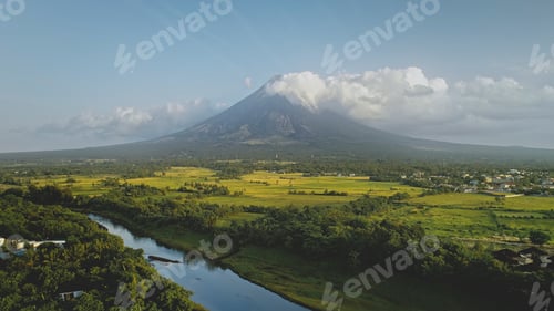 Preview: Hillside river at erupt volcano: green grass shore at Philippines countryside aerial. Fields, valley