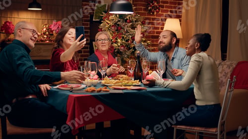 Preview: Beautiful woman presenting Christmas dinner to friend through smartphone internet video call.