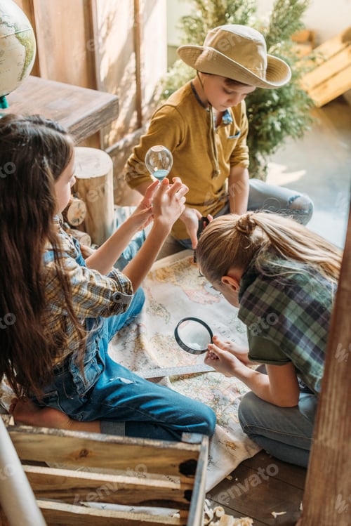 Preview: cute kids playing treasure hunt with map on porch